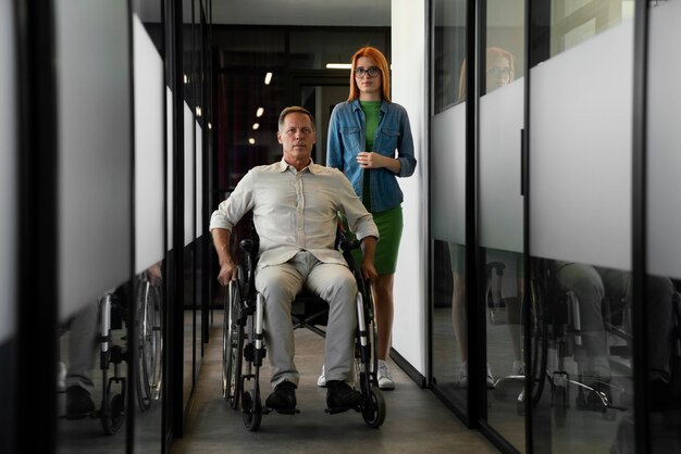 Homme en fauteuil roulant ayant un travail de bureau inclusif