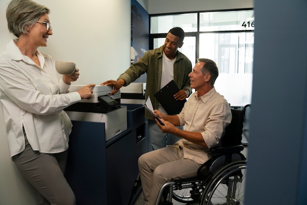 Photo gratuite homme en fauteuil roulant ayant un travail de bureau