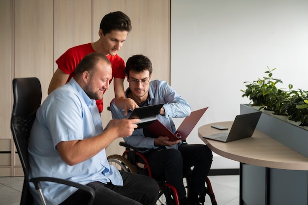 Homme en fauteuil roulant travaillant vue de face