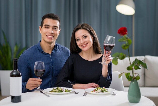 Homme et femme acclamant leur dîner romantique
