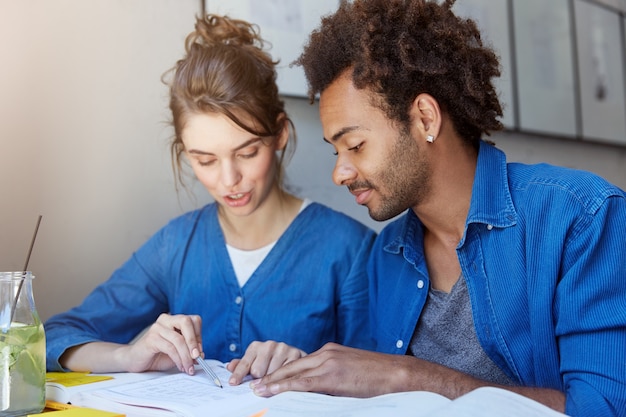 Homme et femme assis dans un café et étudier