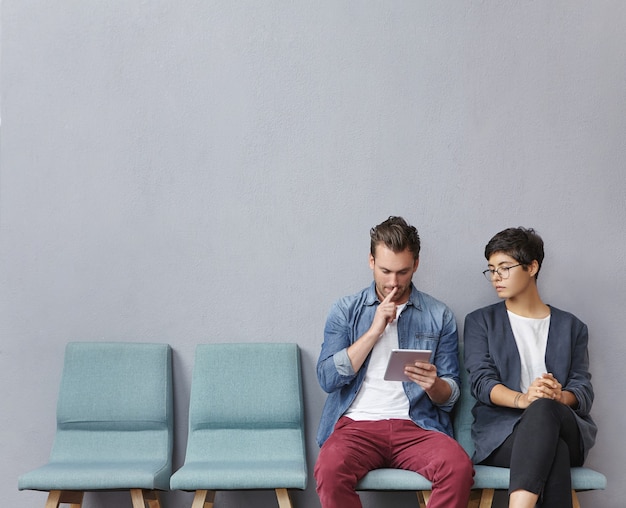 Homme et femme assis dans la salle d'attente