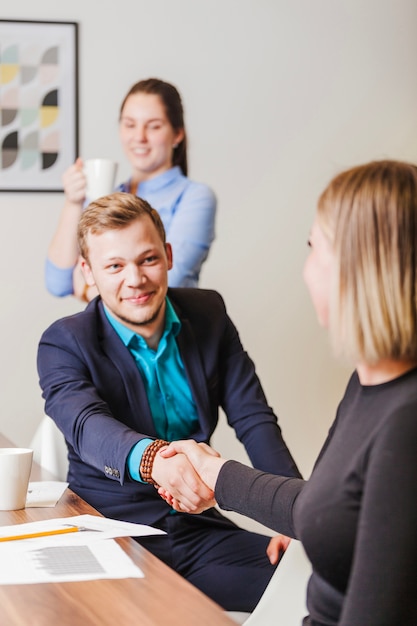 Photo gratuite homme et femme au bureau serrant la main