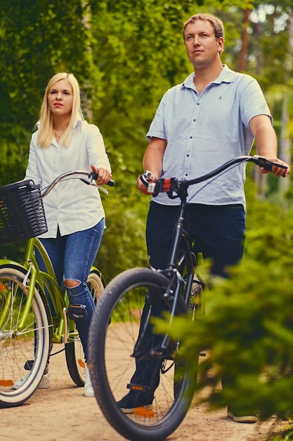 Un homme et une femme sur une balade à vélo dans un parc sauvage.