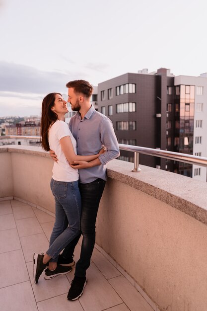 Homme femme, sur, balcon, à, coucher soleil, dans ville