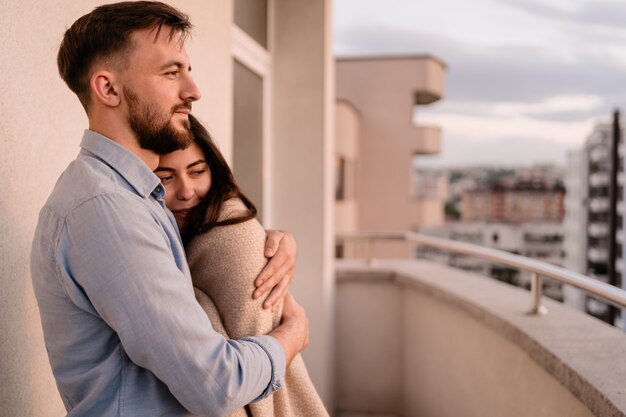 Homme femme, sur, balcon, à, coucher soleil, dans ville