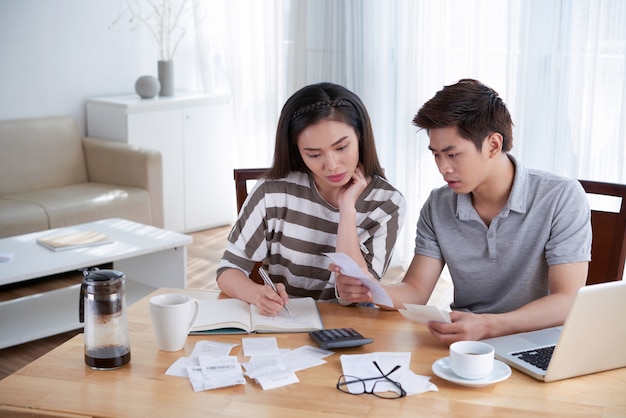 Homme et femme calculant le budget domestique à la maison