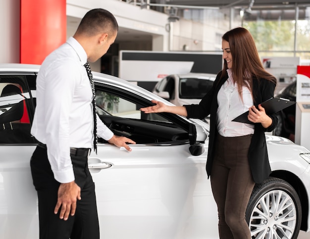 Homme et femme chez un concessionnaire automobile