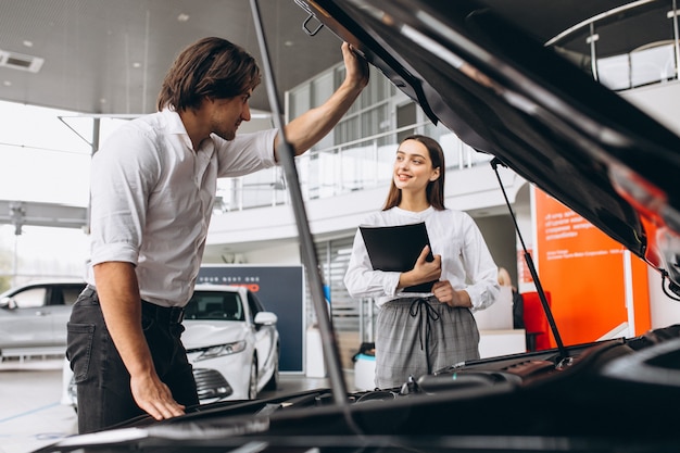 Homme et femme choisissant une voiture dans une salle d'exposition