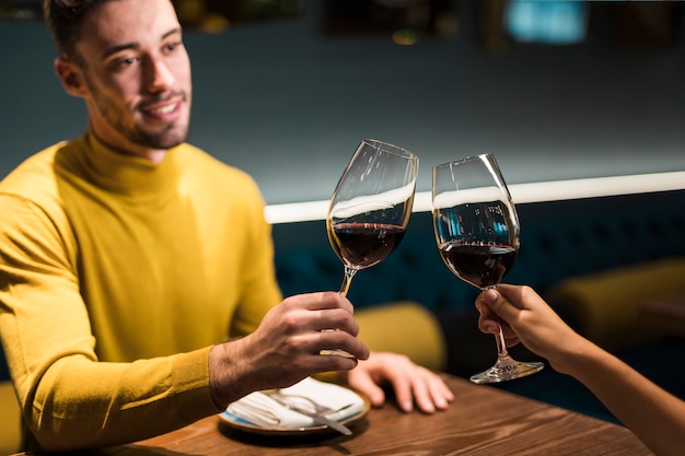 Homme, femme, cliquetis, verres vin, table, restaurant