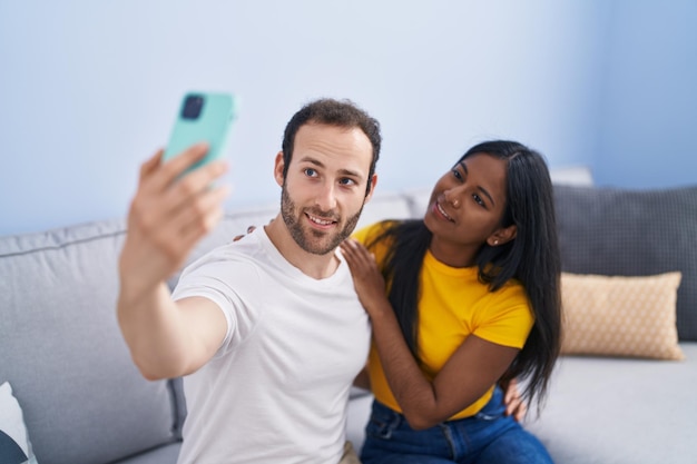 Photo gratuite homme et femme couple interracial faisant selfie par smartphone à la maison