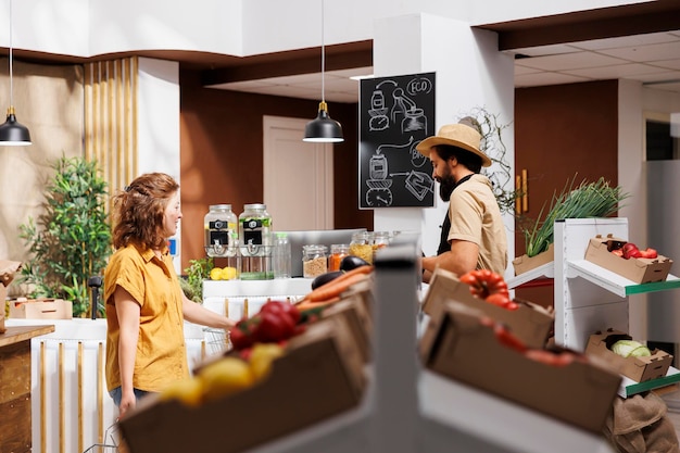 Photo gratuite un homme et une femme dans un magasin zéro déchets remplissant des paniers d'épicerie avec des légumes sains d'origine locale des clients respectueux de l'environnement achetant des pesticides organiques et de la nourriture gratuite dans le magasin du quartier.