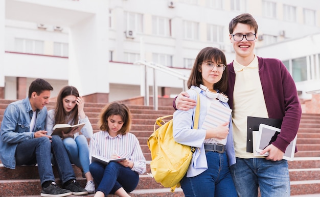 Homme et femme debout, embrassant et regardant la caméra