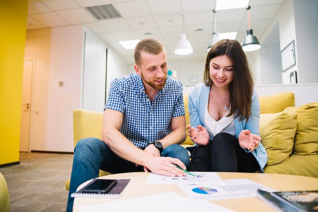 Homme et femme discutant des graphiques dans le hall