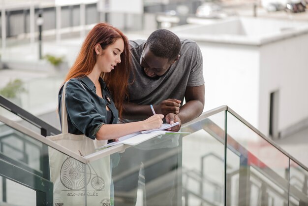 Homme et femme avec des documents sur les escaliers