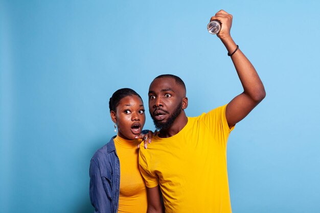 Homme et femme effrayés vérifiant le problème avec la lampe de poche, ayant une expression faciale anxieuse. Couple effrayé et désemparé à la recherche d'un son de peur pour éviter le choc. Petite amie et petit ami effrayés