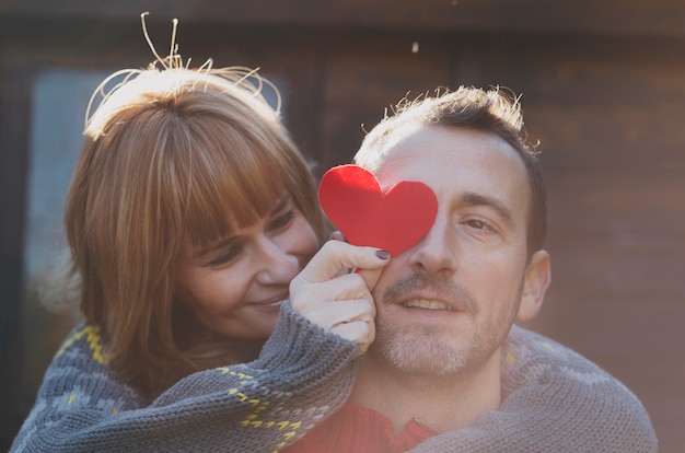 Homme et femme embrassant avec coeur de papier