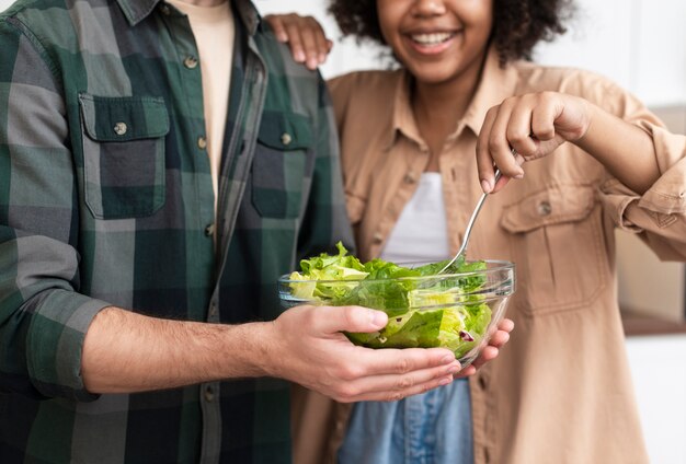Homme et femme essayant une salade savoureuse