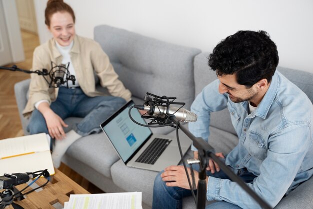 Homme et femme exécutant un podcast ensemble dans le studio