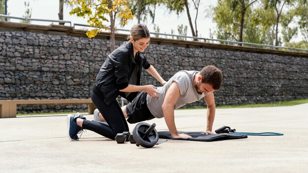 Homme et femme exerçant ensemble à l'extérieur