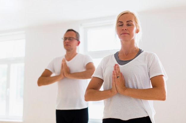 Homme et femme faisant du yoga ensemble