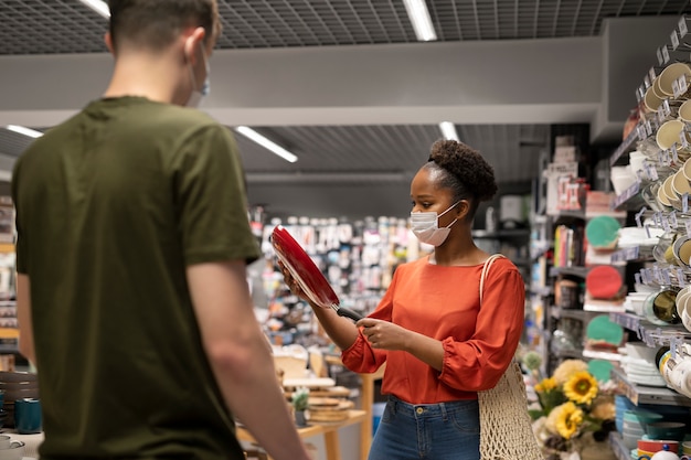 Photo gratuite homme et femme faisant leurs courses à l'épicerie tout en portant des masques médicaux