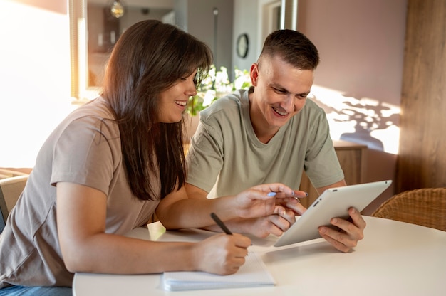 Homme et femme faisant une liste de courses avec tablette