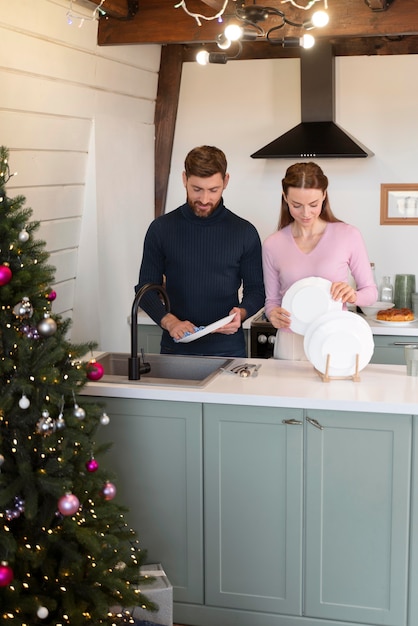 Homme et femme faisant la vaisselle ensemble à Noël