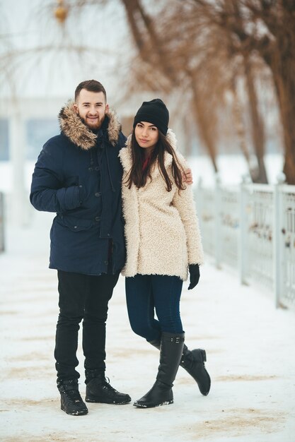 Homme et femme marchant dans le parc d'hiver