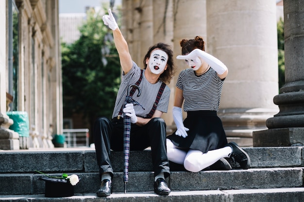 Homme et femme mime artiste gesticulant assis dans l&#39;escalier