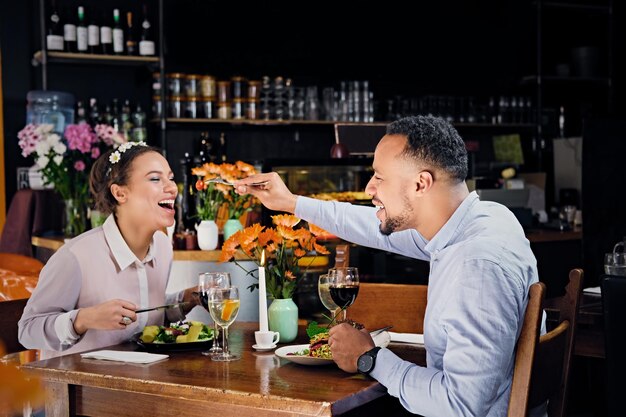 Homme et femme noirs américains mangeant de la nourriture végétalienne dans un restaurant.
