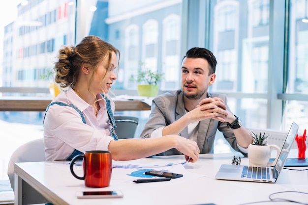 Homme et femme parlant au bureau