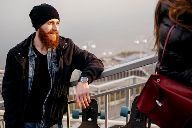 Photo gratuite homme et femme avec planche à roulettes à l'extérieur