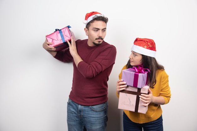 Homme et femme posant avec des cadeaux de Noël.