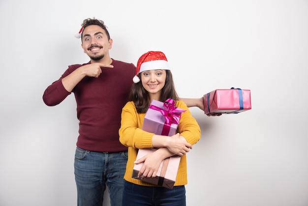 Homme et femme posant avec des cadeaux de Noël.