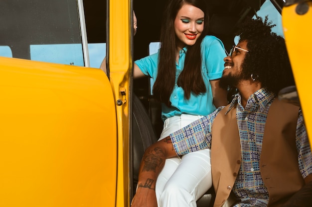 Homme et femme posant dans un style rétro avec voiture