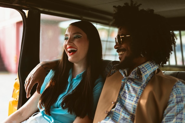 Homme et femme posant ensemble dans un style rétro à l'intérieur du véhicule