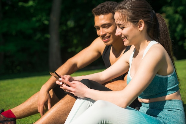 Homme et femme prenant un selfie dans un parc