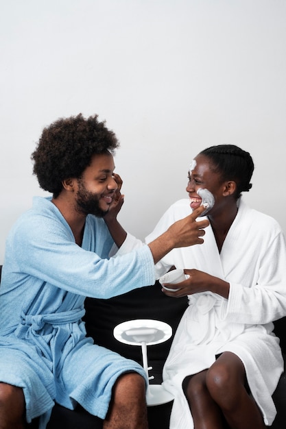 Homme et femme prenant soin de leur visage à la maison