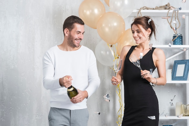 Homme et femme préparant à boire du champagne