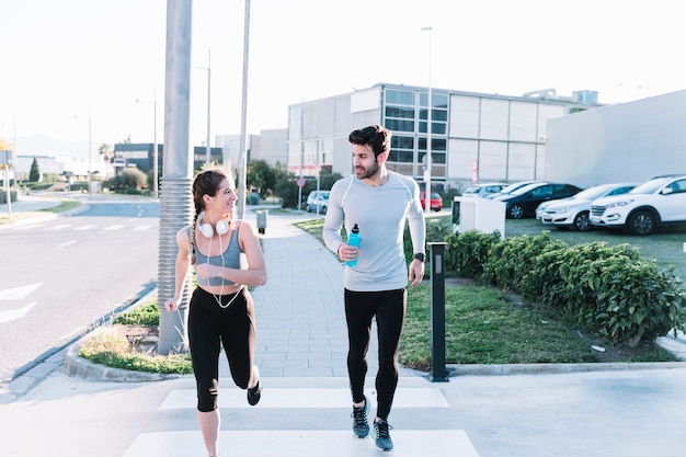 Homme et femme qui court sur le passage pour piétons