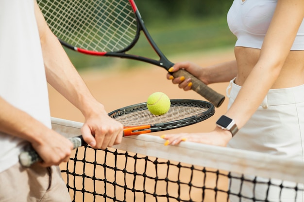 Homme et femme avec des raquettes de tennis