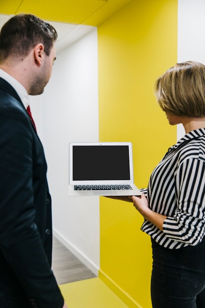 Photo gratuite homme et femme regardant un ordinateur portable au bureau