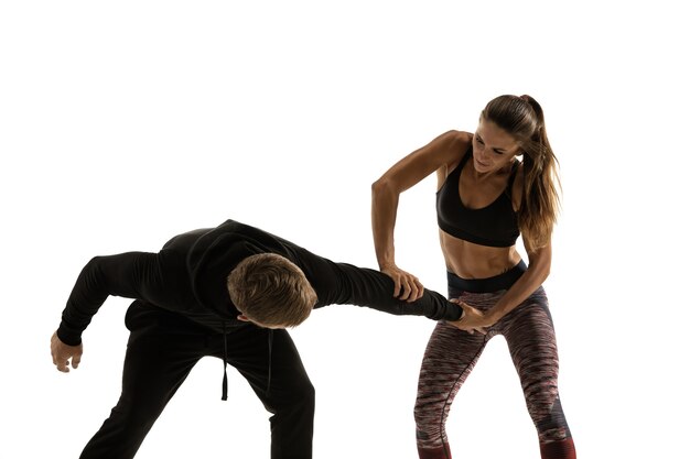 Homme et femme se battre sur blanc, concept d'autodéfense des femmes