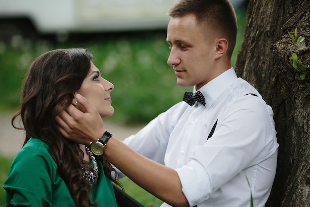 Homme et femme se détendre sur l'herbe sous un arbre