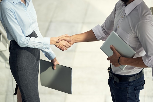 Homme et femme se saluent en se serrant la main au bureau