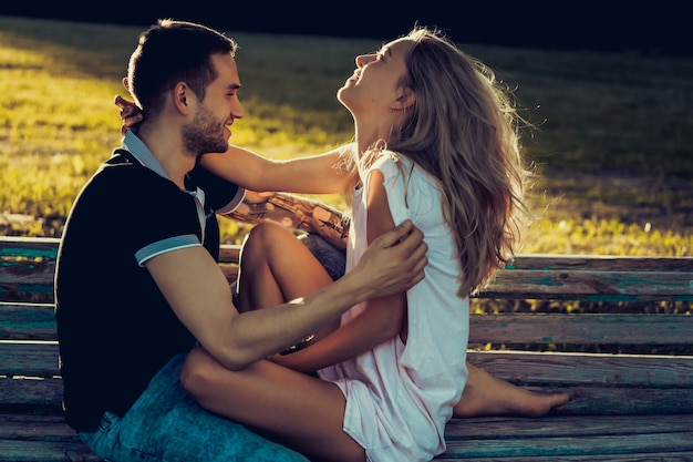 Photo gratuite un homme et une femme sont assis sur un banc et s'embrasser