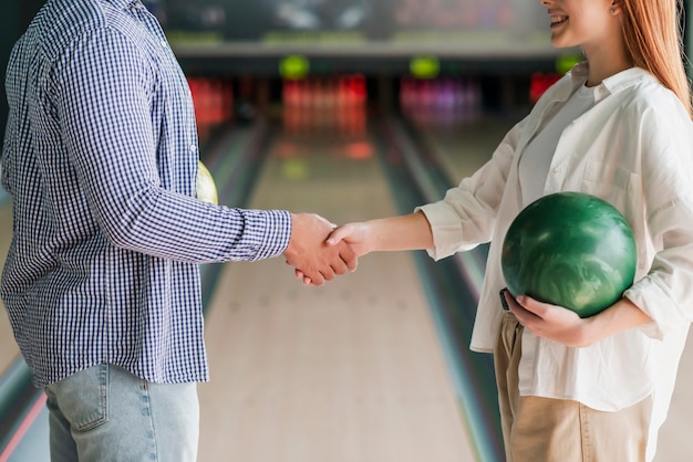Homme et femme tenant des boules de bowling