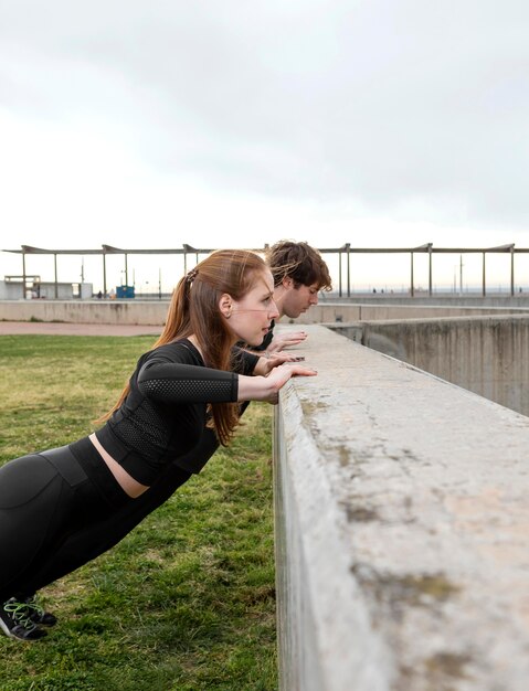 Homme et femme en tenue de sport exerçant à l'extérieur