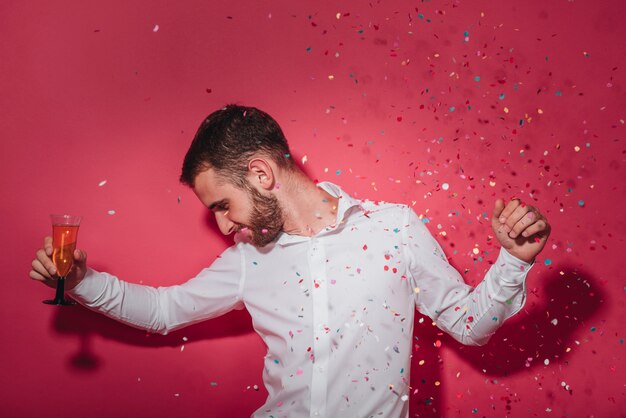 Homme de fête posant avec des confettis